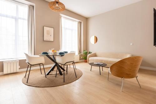 a living room with a table and chairs and a couch at Au Chat Qui Dort Lille - Gare in Lille