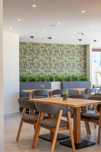 a dining room with wooden tables and chairs at Ammos Eco Residence in Karteros