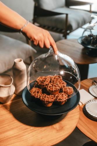 a person is preparing waffles on a plate on a table at M Boutique Hotel - Designed for Adults in Paphos City