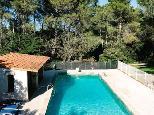 une piscine dans une cour arrière avec une clôture et des arbres dans l'établissement Mas Frederi - Maison avec piscine pour 10, à Paradou