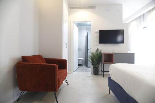 ハイファにあるStylish Modern Studios - Port & Beach Apartments, Haifaのベッドと椅子とテレビのある寝室