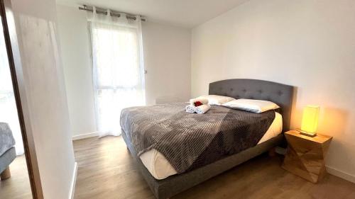 une chambre avec un lit avec un animal en peluche dessus dans l'établissement La Perle Ariane-Vue Panoramique Wifi Parking Lac Top ProsConciergerie, à Lattes