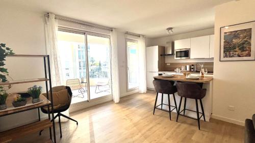 - une cuisine avec un comptoir et des chaises dans la chambre dans l'établissement La Perle Ariane-Vue Panoramique Wifi Parking Lac Top ProsConciergerie, à Lattes