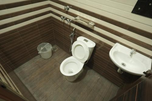 a bathroom with a toilet and a sink at Anna Hotel in Trivandrum