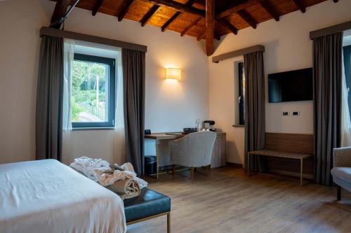 a bedroom with a bed and a desk and a window at Le Cappuccinelle Suites&SPA in Perugia