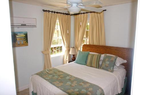 a bedroom with a bed and a ceiling fan at ZenBreak Silver Sands Villa 3 in Christ Church
