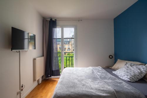 une chambre avec un lit et une grande fenêtre dans l'établissement Bleu en Bois - À Chessy à 10 min de Disneyland, à Chessy