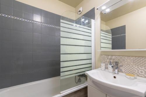 une salle de bain avec un lavabo blanc et une douche dans l'établissement Bleu en Bois - À Chessy à 10 min de Disneyland, à Chessy