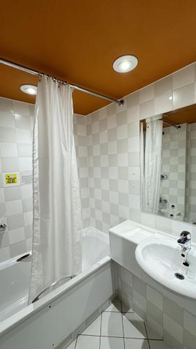 a bathroom with a sink and a tub and a shower at Britannia Hotel Bolton in Bolton