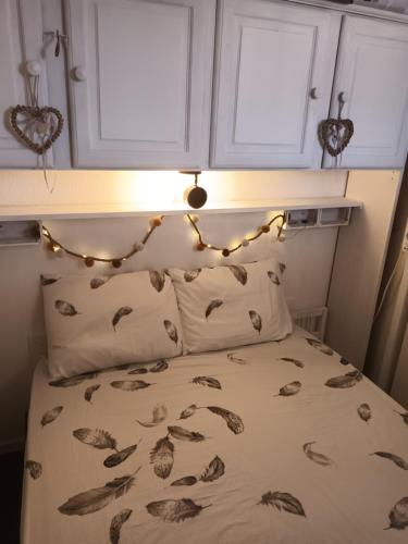 - un lit avec une tête de lit et des lumières au-dessus dans l'établissement Petit appartement Le Victoria's Beach Barcarès - Parking privé - Direct plage - 5 minutes à pied du Lydia - 3 Personnes - Pas de linge de maison - Pas de Wifi - Pas de climatisation -, au Barcarès