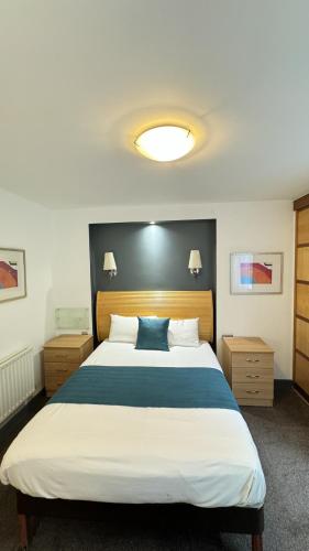 a bedroom with a large bed with a blue pillow at Britannia Hotel Bolton in Bolton