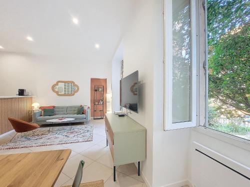 un salon avec un canapé et une fenêtre dans l'établissement Nestor&Jeeves - BEL AIR - City Center - Modern, à Nice