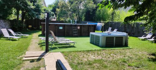 a yard with chairs and a green heater on the grass at Hôtel Le P'tit Monde in Montignac