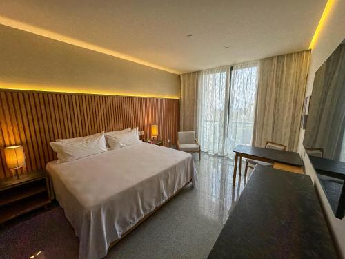 a hotel room with a large bed and a desk at Hotel Mio Riviera Nayarit - Adults Only in Nuevo Vallarta 