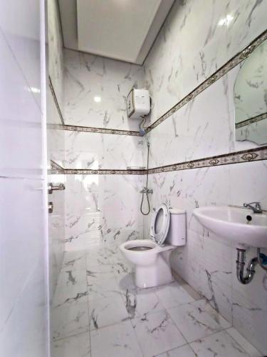 a white bathroom with a toilet and a sink at Villa Tiara 2 in Cikundul