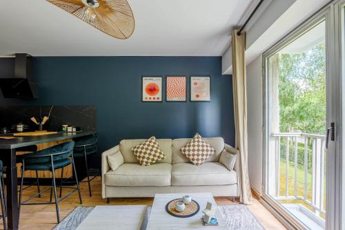 un salon avec un canapé et une table dans l'établissement Appartement Croisé Laroche - 5 min de Lille, à Marcq-en-Barœul