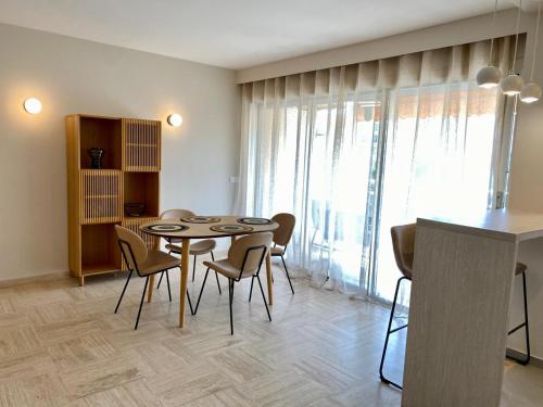 une salle à manger avec une table et des chaises dans l'établissement Joli appartement prés de la mer, à Cannes
