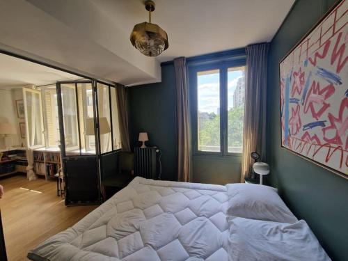 une chambre avec un lit blanc et une grande fenêtre dans l'établissement Luxe parisien, charme 16e - À 2 pas du Trocadéro, à Paris