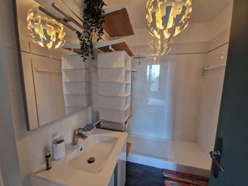 une salle de bain avec un lavabo, un miroir et des serviettes dans l'établissement Luxe parisien, charme 16e - À 2 pas du Trocadéro, à Paris