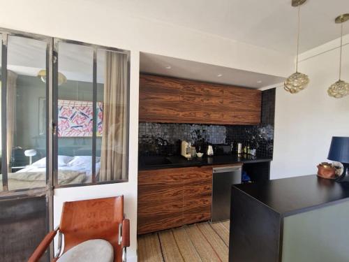 une cuisine avec un comptoir noir et une chambre dans l'établissement Luxe parisien, charme 16e - À 2 pas du Trocadéro, à Paris