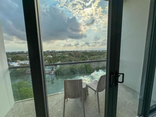 a balcony with two chairs and a view of the water at Hotel Mio Riviera Nayarit - Adults Only in Nuevo Vallarta 