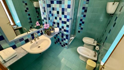 une salle de bains avec lavabo, toilettes et miroir dans l'établissement La Mansarda, à Assise