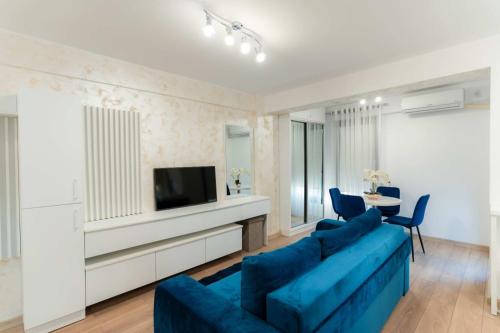 a living room with a blue couch and a tv at Irina's Premier Properties at Seven Palms, Saturn in Saturn