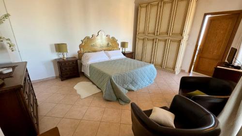 a bedroom with a bed and two chairs in it at B&B La Zuppa Inglese in Assisi