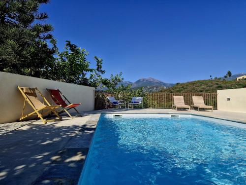 - une piscine avec 2 chaises longues dans l'établissement Vistamare Locations avec Piscine saint florent, à Saint-Florent