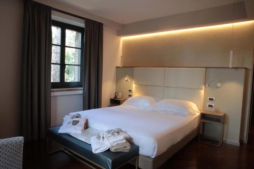 a bedroom with a large bed with towels on it at Le Cappuccinelle Suites&SPA in Perugia