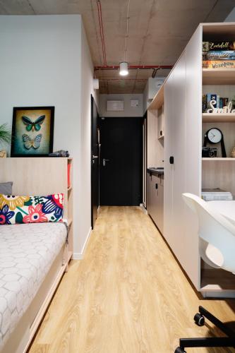 a hallway with a bed and a desk in a room at Chillout Dorm Warszawa by BookingHost in Warsaw
