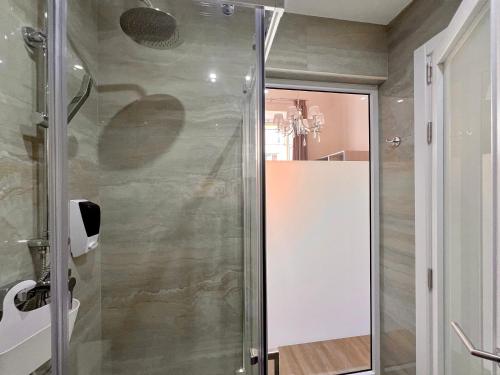 a shower with a glass door in a bathroom at Ta' Dun Martin and taz-Zija Bed and Breakfast in Nadur