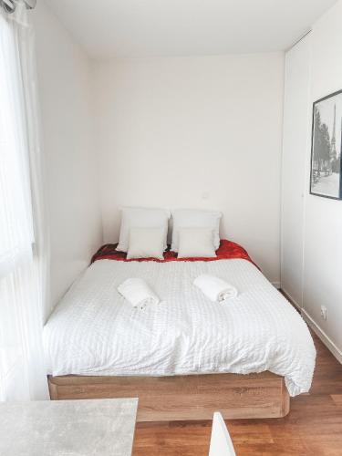 une chambre blanche avec un lit avec des draps et des oreillers blancs dans l'établissement Studio à 10 mins de Paris, à Rosny-sous-Bois