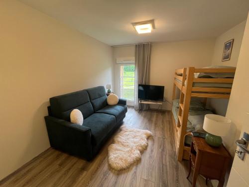 - un salon avec un canapé et des lits superposés dans l'établissement Appartement au Golf Barcelonnette, à Barcelonnette