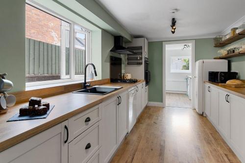 a kitchen with white cabinets and a sink at Quayside Haven in Exeter