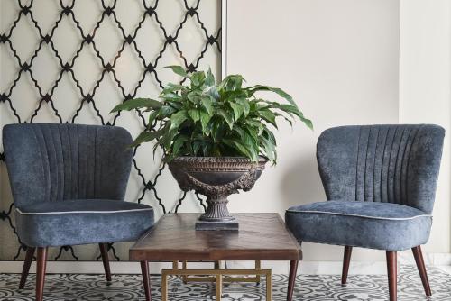 two chairs and a vase with a plant on a table at Legacy Gastro Suites in Heraklio Town