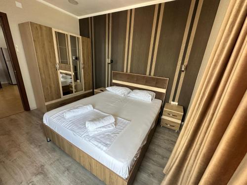 Schlafzimmer mit einem Bett mit weißer Bettwäsche und Handtüchern in der Unterkunft Bakva's apartment in Batumi