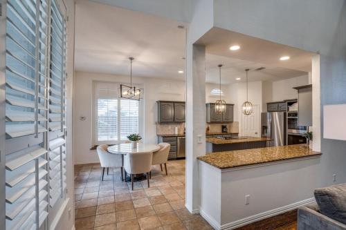 a kitchen and living room with a table and a dining room at 5br Lux! Pool, Games & Theater in Rowlett