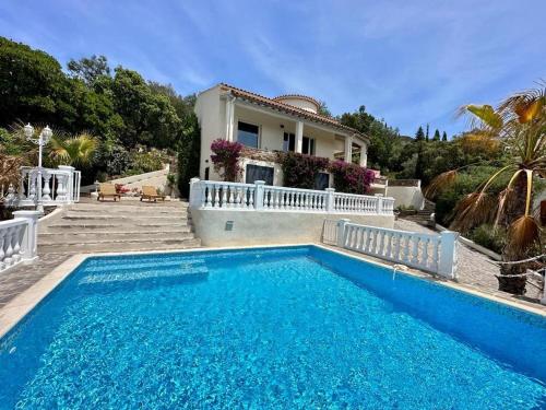 une piscine devant une maison dans l'établissement Villa moderne 6 CH pour 12 avec piscine privée, clim et parking aux Issambres - FR-1-768-24, aux Issambres