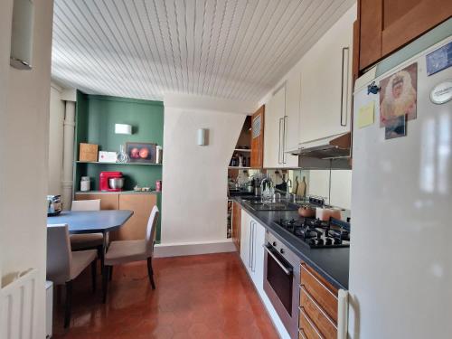 une cuisine avec une table et un comptoir dans l'établissement Havre de paix aux Batignolles, à Paris