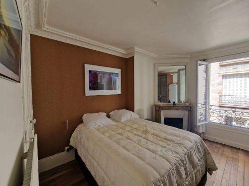 - une chambre avec un lit et une cheminée dans l'établissement Havre de paix aux Batignolles, à Paris