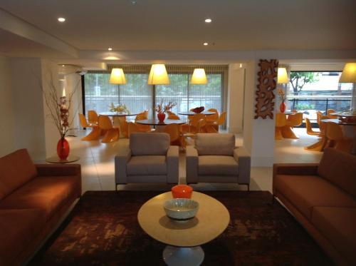a living room with couches and a table and chairs at Landscape Beira Mar - Lindo, Luxo, Frente mar in Fortaleza