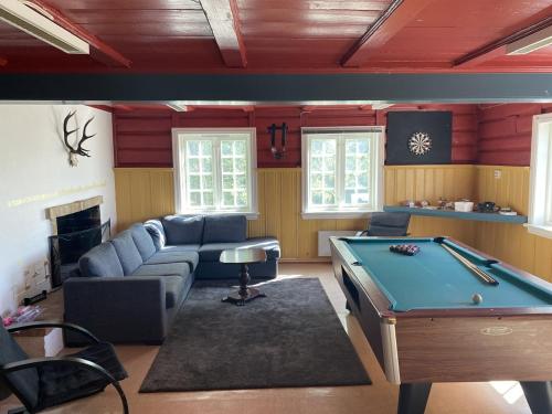 a living room with a couch and a pool table at Velferden Mågerø in Nord Måkerøy
