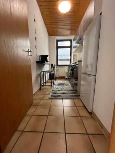 a hallway leading to a kitchen with a refrigerator at Charmantes Apartment in Karlsruhe