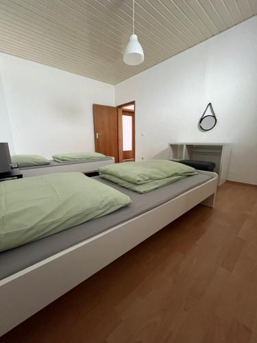 two beds in a white room with at Charmantes Apartment in Karlsruhe