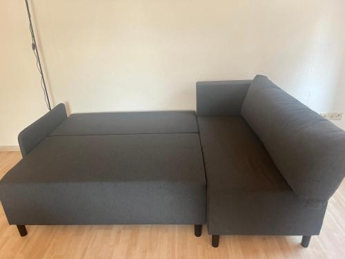 a gray couch sitting on a wooden floor at Charmantes Apartment in Karlsruhe