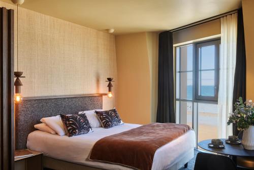 a hotel room with a bed and a large window at Mercure St Malo Front de Mer in Saint Malo