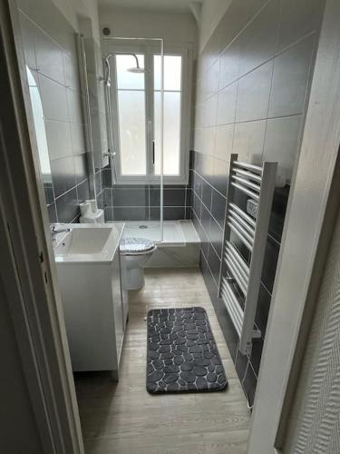 La salle de bains est pourvue d'un lavabo, de toilettes et d'une fenêtre. dans l'établissement Le Chaleureux, au Havre