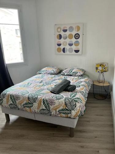 un lit avec des oreillers dessus dans une chambre dans l'établissement Le Chaleureux, au Havre