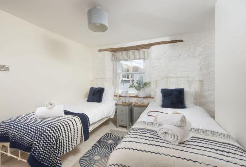 two beds in a bedroom with blue and white at Oriel Cottage in St. Agnes